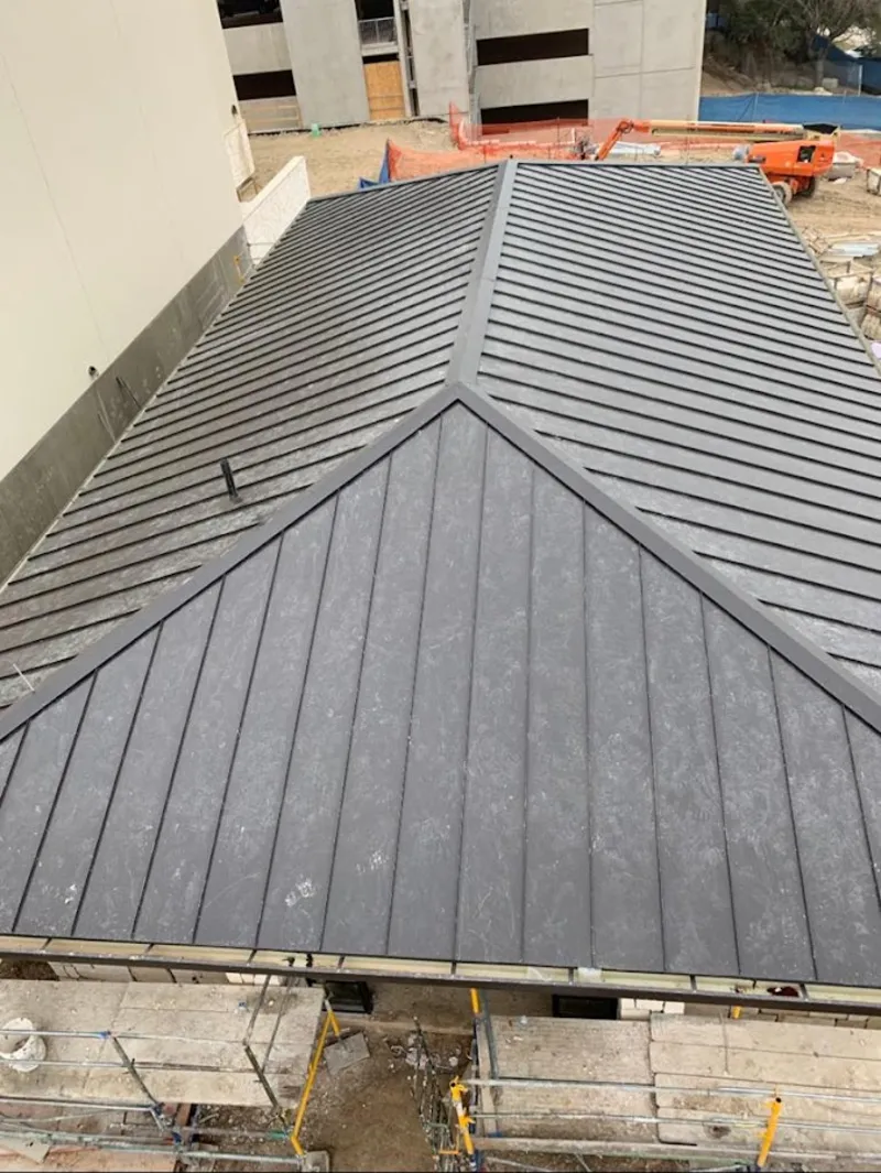 Commercial metal roof construction with crane equipment in Burtonsville